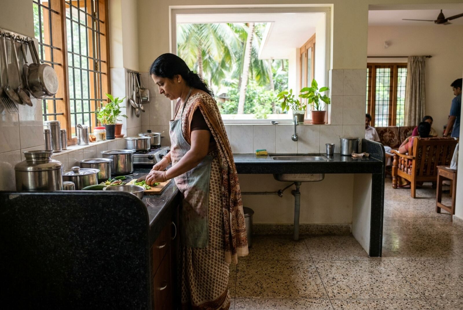 A house maid preparing vegetables in a bright Kerala kitchen